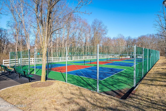 view of sport court featuring a tennis court and fence