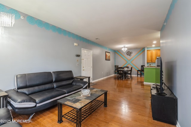 439 Sophee Ln, Lakewood, NJ 08701 - living area with light wood finished floors, baseboards, and an inviting chandelier