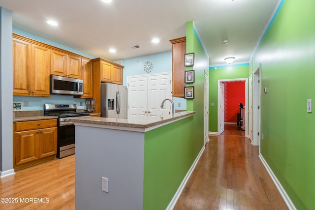439 Sophee Ln, Lakewood, NJ 08701 - kitchen featuring visible vents, crown molding, light wood finished floors, a peninsula, and appliances with stainless steel finishes