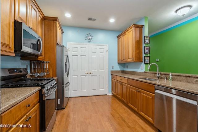 439 Sophee Ln, Lakewood, NJ 08701 - kitchen with visible vents, light wood finished floors, brown cabinets, stainless steel appliances, and a sink