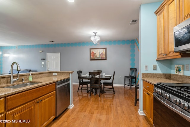 439 Sophee Ln, Lakewood, NJ 08701 - kitchen featuring visible vents, light stone countertops, stainless steel appliances, a sink, and light wood-style floors