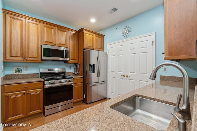 439 Sophee Ln, Lakewood, NJ 08701 - kitchen featuring a sink, visible vents, light stone countertops, appliances with stainless steel finishes, and brown cabinets