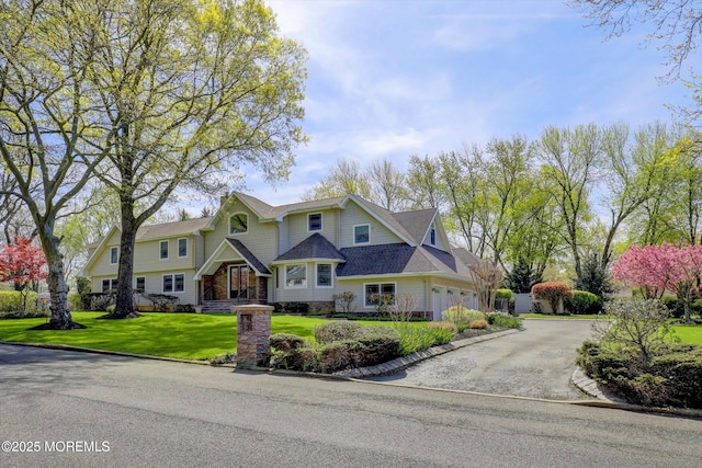 craftsman-style house with driveway and a front yard