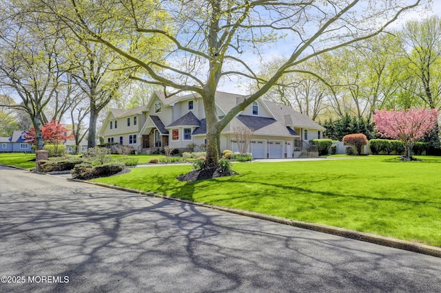 view of front of home with a residential view, an attached garage, a front yard, and driveway