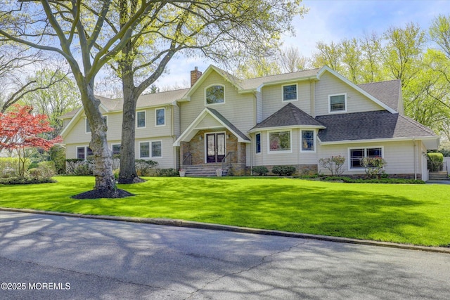 view of front of home featuring a front yard, a shingled roof, and a chimney