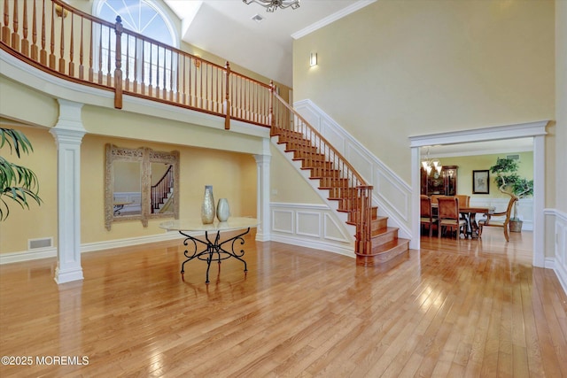interior space with visible vents, a high ceiling, a notable chandelier, and stairway