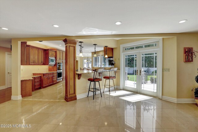 kitchen featuring baseboards, french doors, stainless steel appliances, and ornate columns