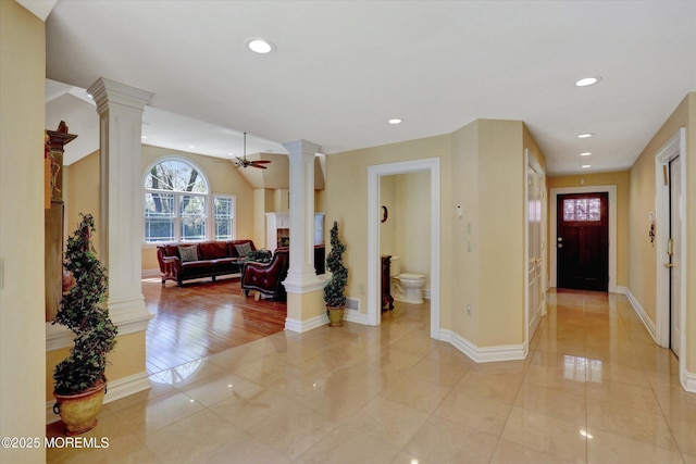 corridor featuring light tile patterned floors, recessed lighting, baseboards, and decorative columns