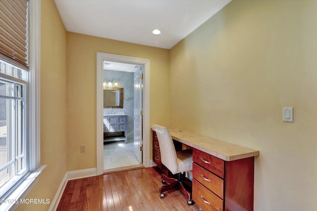 home office featuring baseboards, a wealth of natural light, and light wood-type flooring