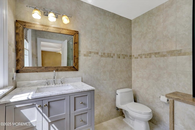 bathroom with tile walls, vanity, and toilet
