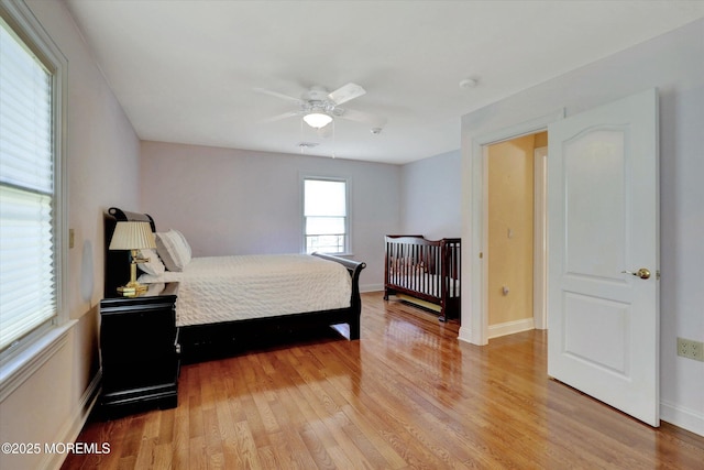 bedroom featuring ceiling fan, baseboards, and light wood-style floors