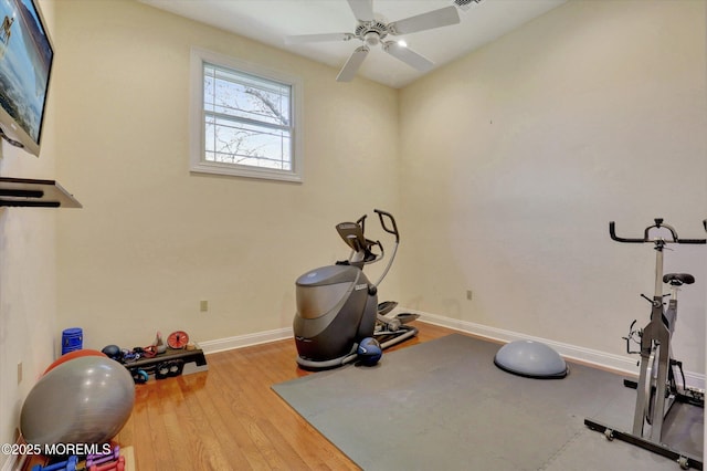 workout room featuring baseboards, a ceiling fan, and wood finished floors