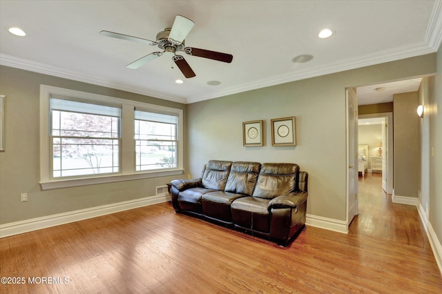 living room with a ceiling fan, light wood finished floors, baseboards, ornamental molding, and visible vents