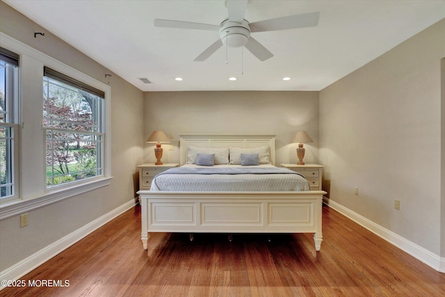 bedroom featuring visible vents, wood finished floors, baseboards, and ceiling fan
