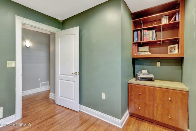 interior space featuring baseboards, visible vents, and light wood-style flooring