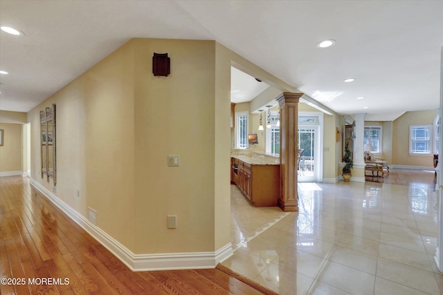 hall with decorative columns, baseboards, and recessed lighting