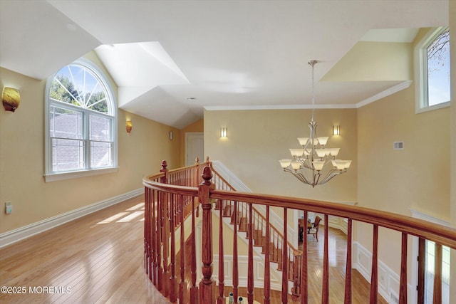 hall featuring lofted ceiling, an upstairs landing, baseboards, light wood-style flooring, and a notable chandelier