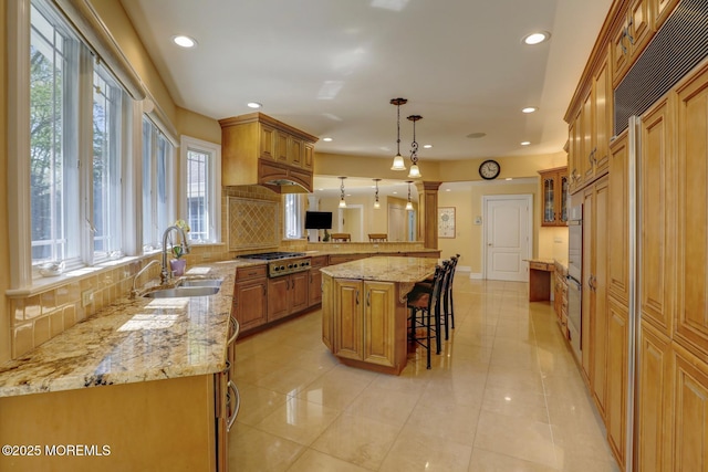 kitchen featuring decorative backsplash, a kitchen breakfast bar, a sink, and recessed lighting