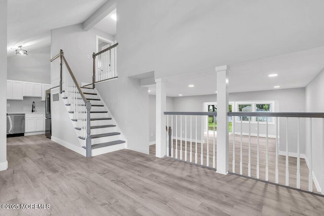 703 Stone Rd, Union Beach, NJ 07735 - unfurnished living room with wood finished floors, high vaulted ceiling, baseboards, ornate columns, and beamed ceiling