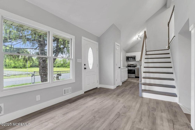 703 Stone Rd, Union Beach, NJ 07735 - entrance foyer featuring light wood-type flooring, stairway, baseboards, and vaulted ceiling