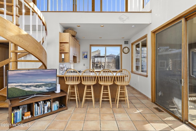 dining space featuring recessed lighting, light tile patterned floors, baseboards, a towering ceiling, and visible vents