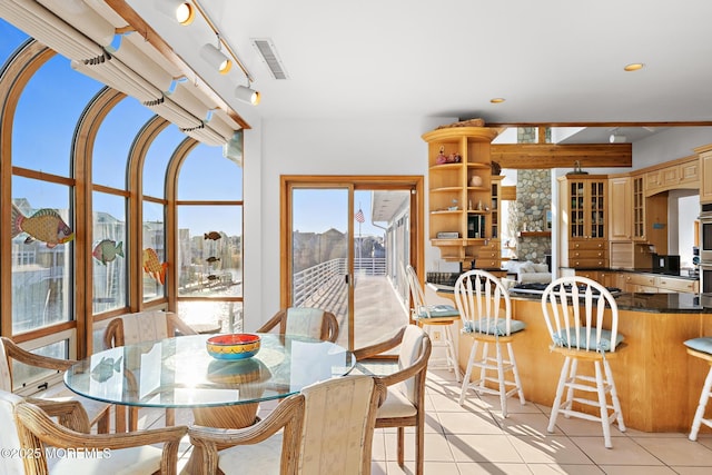 dining area with light tile patterned floors, rail lighting, and visible vents