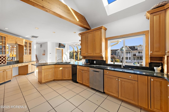 kitchen featuring lofted ceiling with skylight, light tile patterned floors, stainless steel dishwasher, a sink, and a peninsula