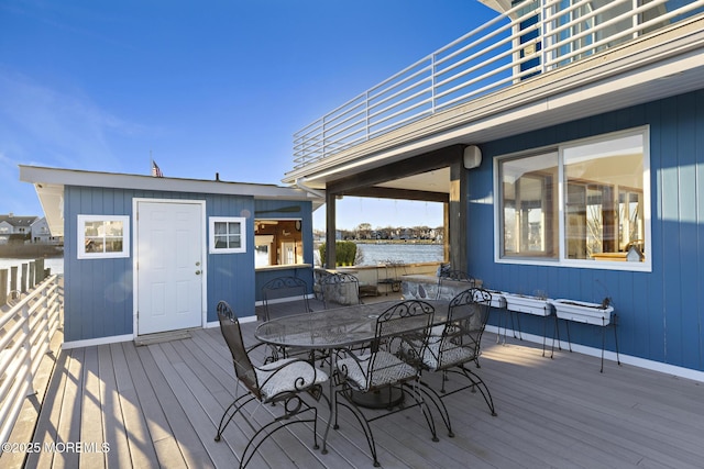 deck featuring a water view and outdoor dining space
