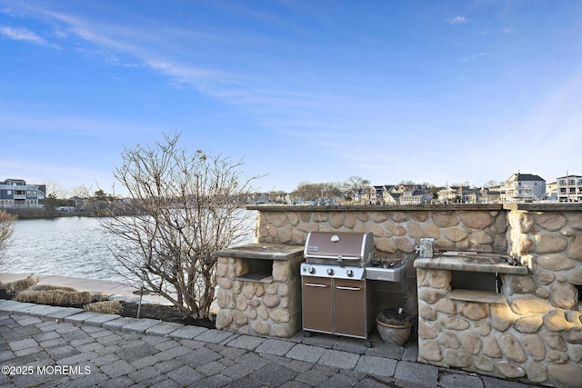 view of patio / terrace with a water view and exterior kitchen