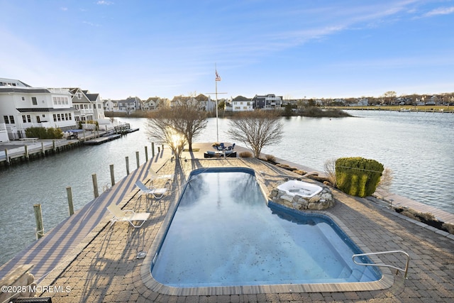 community pool with a water view and a boat dock