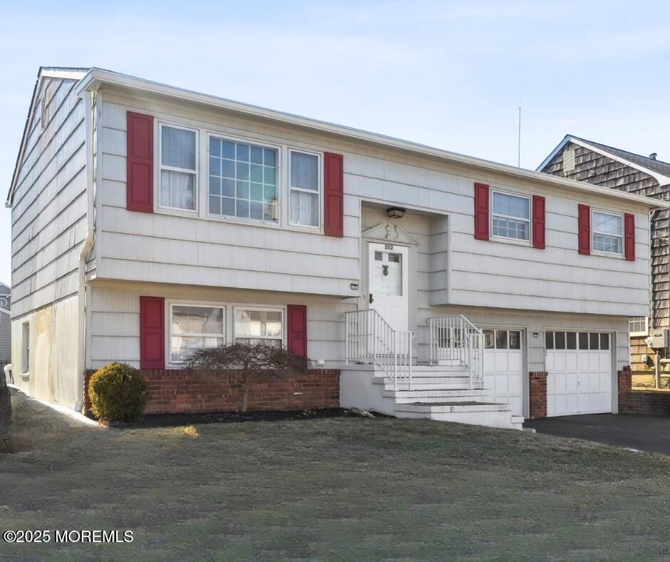 raised ranch featuring driveway and an attached garage