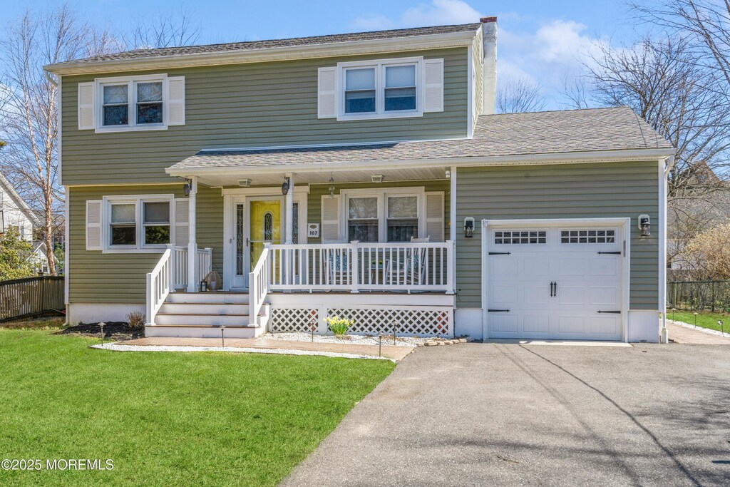 view of front of home featuring a garage, a front lawn, roof with shingles, driveway, and a porch