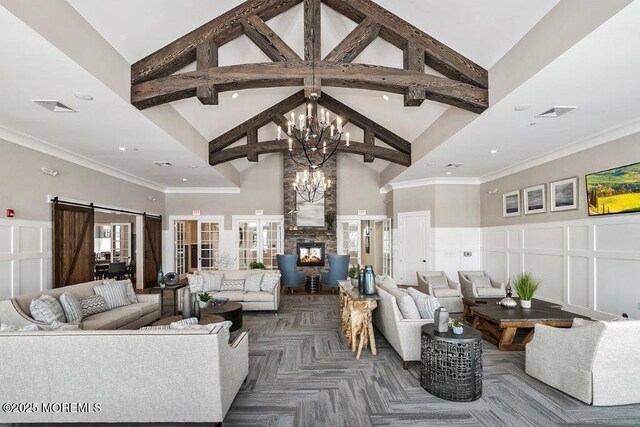 living area featuring an inviting chandelier, visible vents, beam ceiling, high vaulted ceiling, and a decorative wall