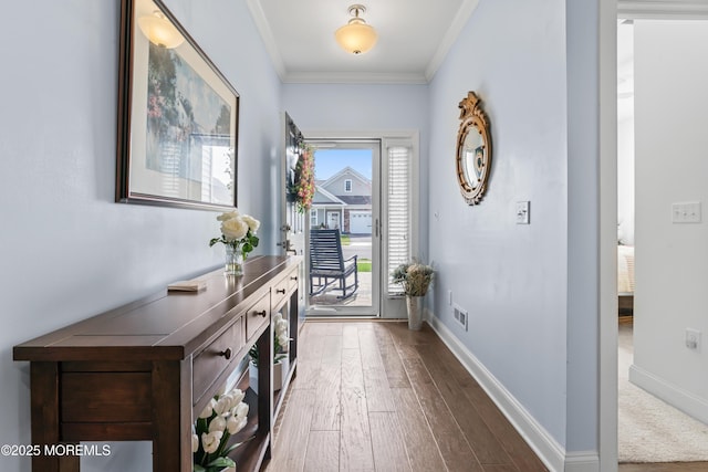 entryway featuring dark wood-style flooring, baseboards, visible vents, and crown molding
