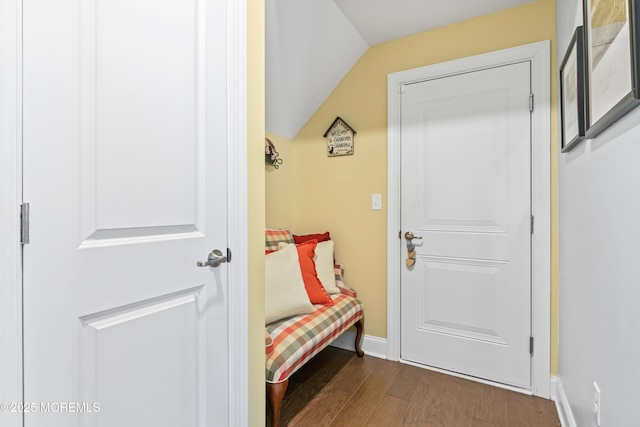 doorway featuring dark wood-style flooring, baseboards, and lofted ceiling