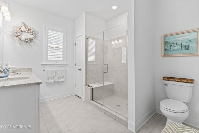 bathroom featuring toilet, a shower stall, vanity, and baseboards
