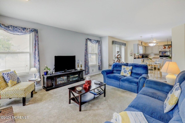 living area featuring light colored carpet and baseboards
