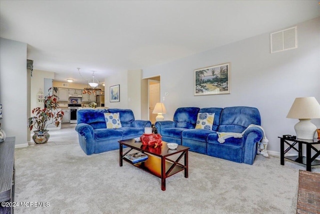 living room featuring light carpet, baseboards, and visible vents