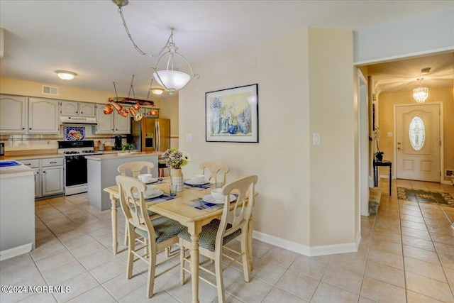 dining area featuring light tile patterned floors, baseboards, and visible vents