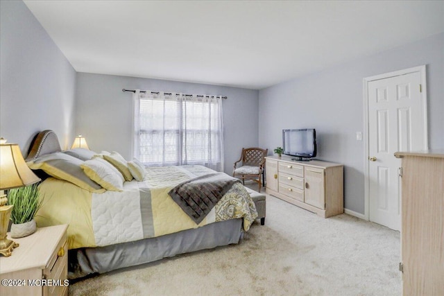 bedroom featuring baseboards and light carpet
