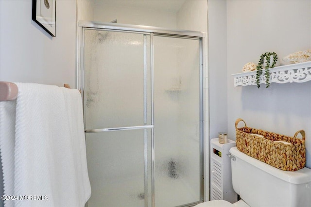 bathroom featuring toilet and a shower stall