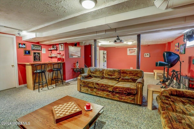 living room with a bar, a textured ceiling, baseboards, and carpet