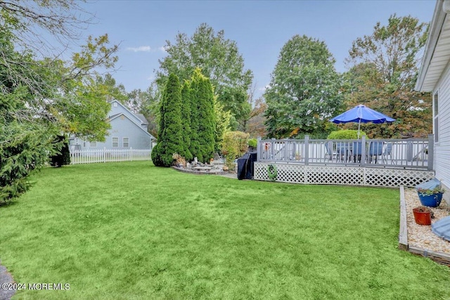 view of yard featuring fence and a deck