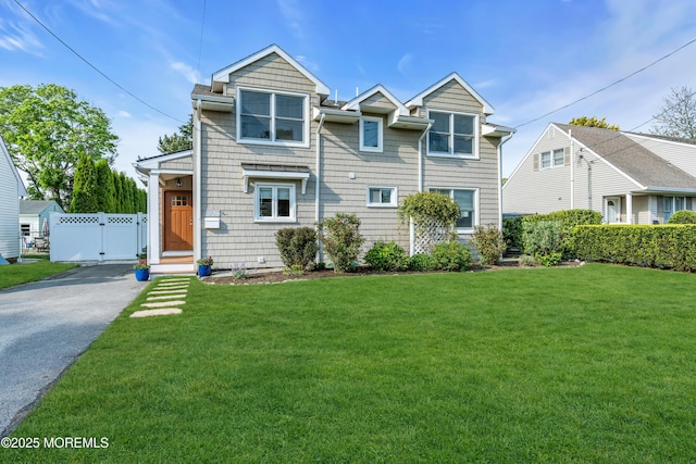 view of front of home featuring asphalt driveway and a gate