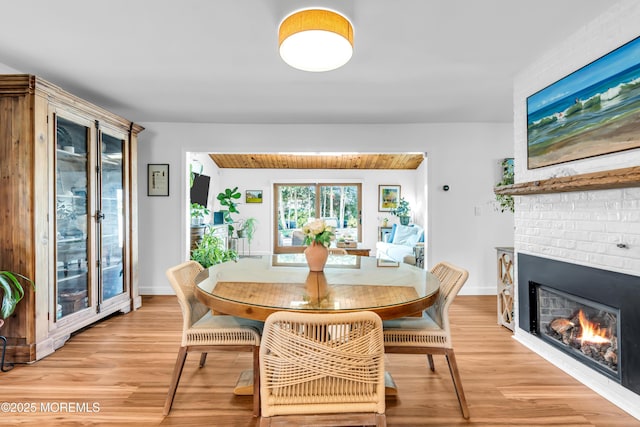 dining area featuring light wood finished floors and a fireplace