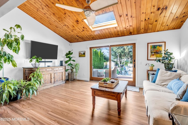 living room featuring a skylight, a ceiling fan, vaulted ceiling, light wood-style floors, and wooden ceiling