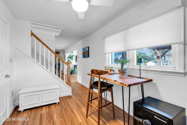 dining area with healthy amount of natural light, light wood-style flooring, a ceiling fan, and stairway
