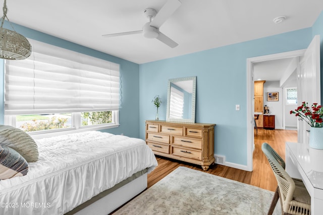 bedroom featuring wood finished floors, baseboards, and ceiling fan