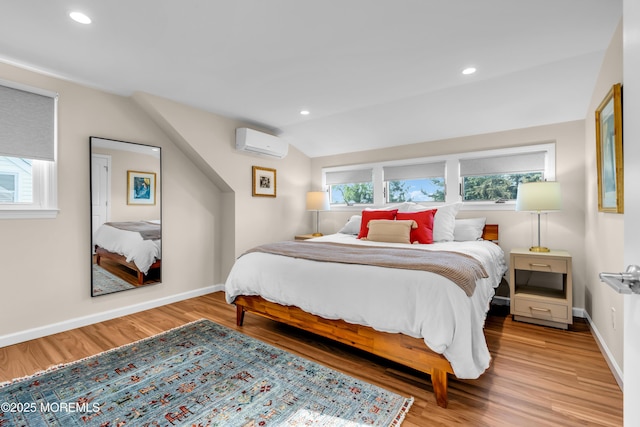 bedroom with a wall mounted AC, light wood-type flooring, baseboards, recessed lighting, and vaulted ceiling