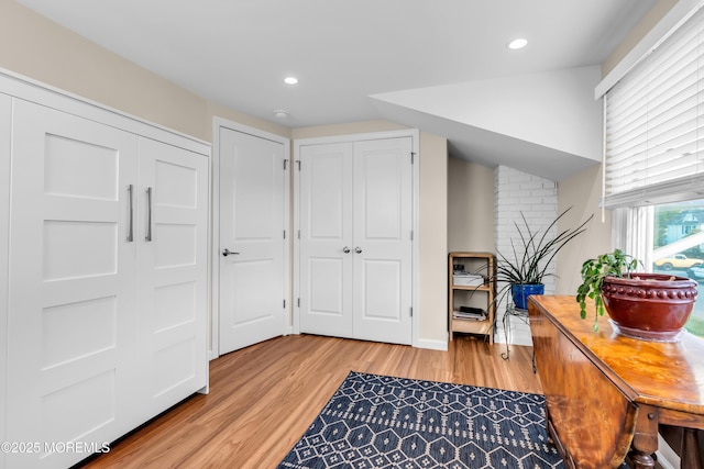 hallway featuring light wood-type flooring, recessed lighting, and baseboards